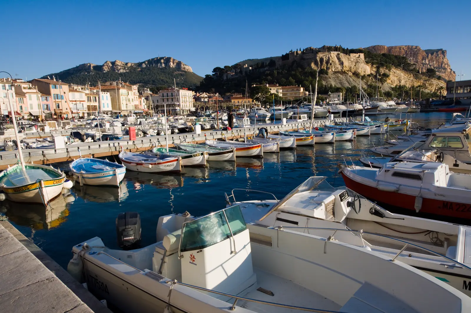 Le port de Cassis, ses bateaux et le Cap Canaille en arrière-plan